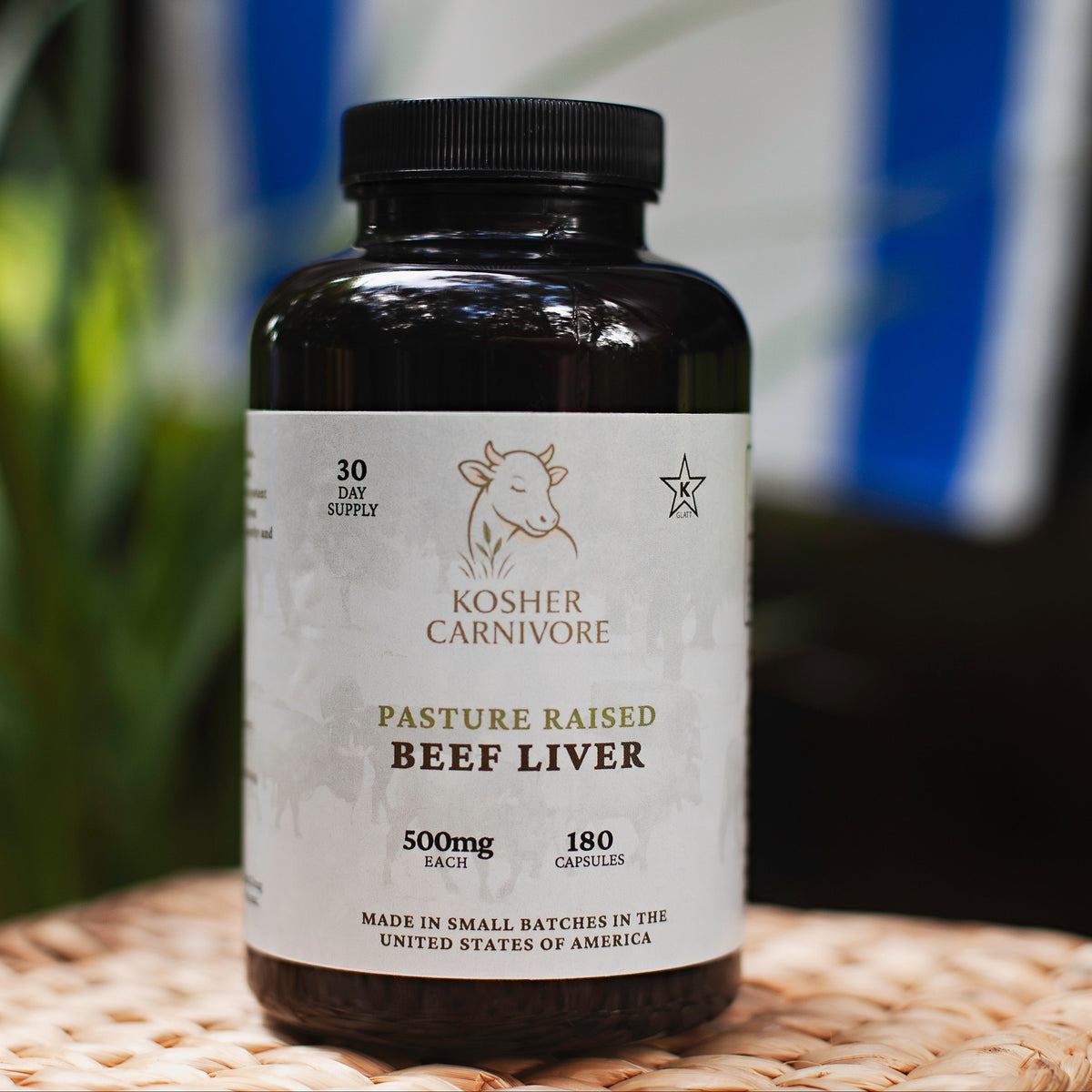 Bottle of kosher beef liver supplement with a blurred flag in the background